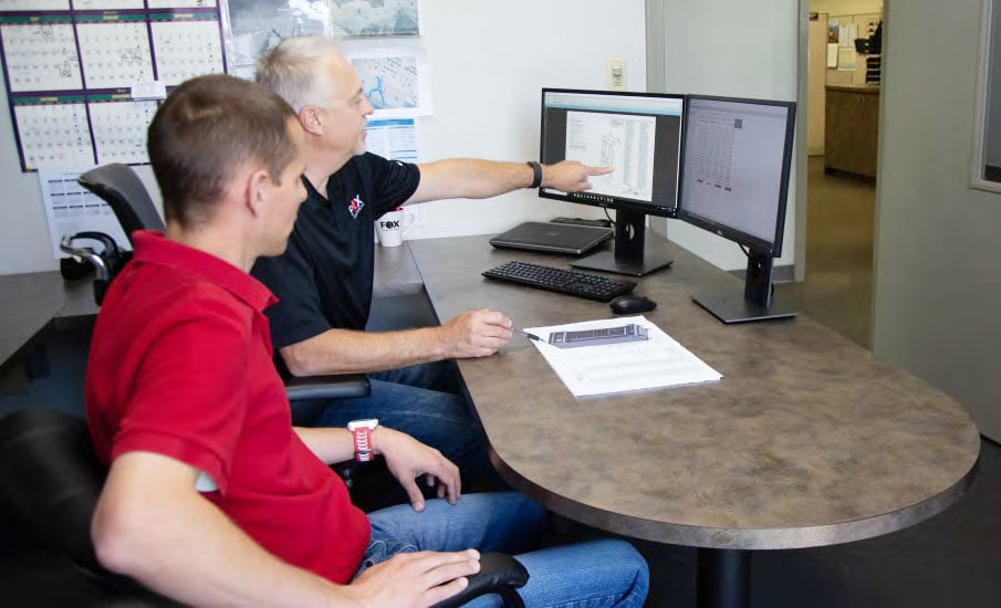 Project-Program managers at desktop computer working on defense manufacturing project at Fox Valley Metal Tech