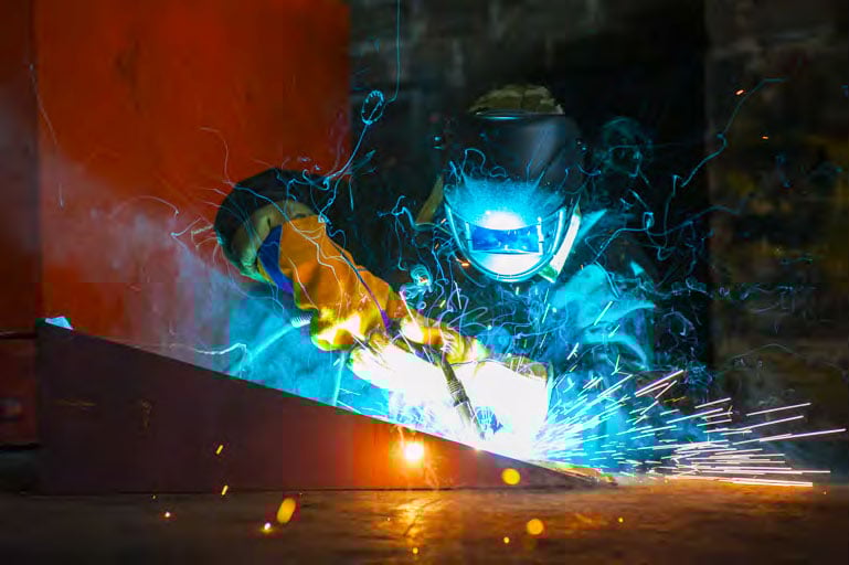 Welder at Fox Valley Metal Tech doing precision fabrication in defense manufacturing for nuclear aircraft carrier